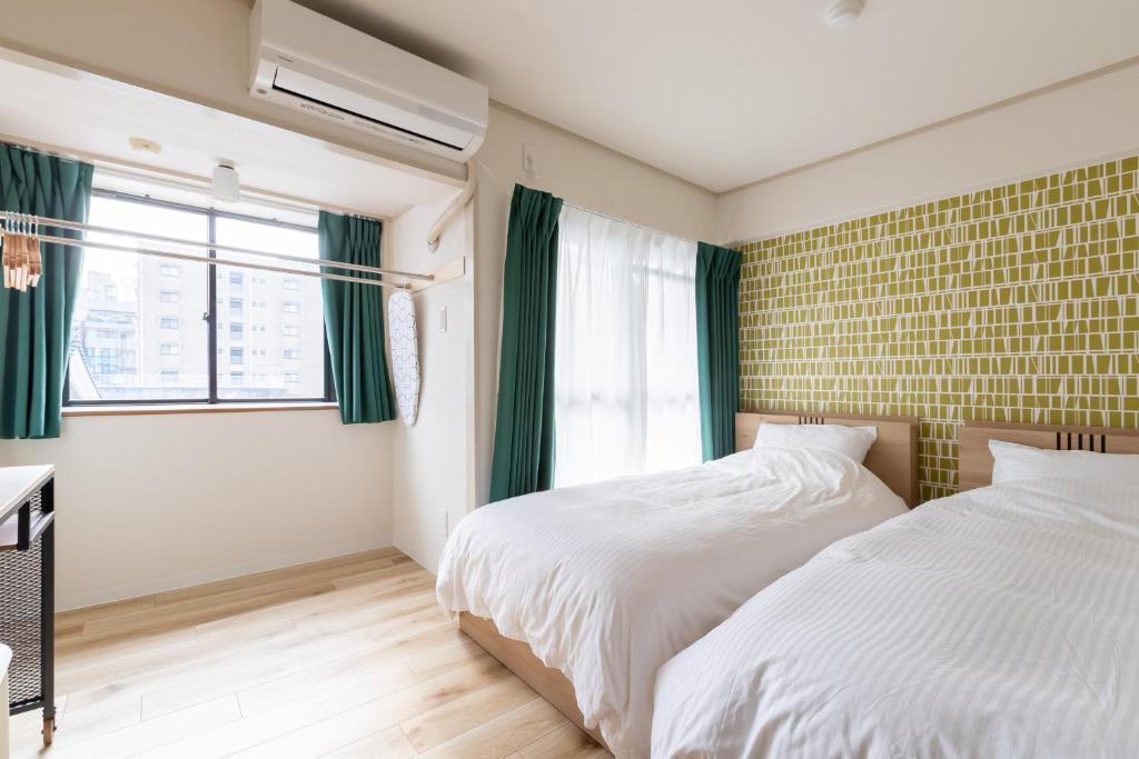 1 Schlafzimmer mit 2 Betten und einem Fenster in der Unterkunft グランシャーギ in Osaka