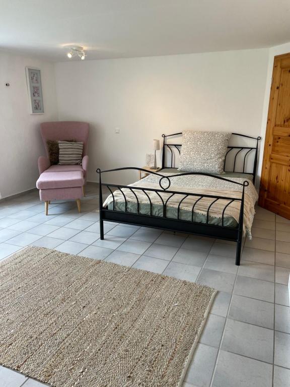 a bedroom with a bed and a chair and a rug at Bei Hempels in Breitscheid