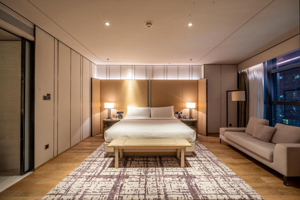 成都市にある成都 マリオット ホテル ファイナンシャル センターのベッドルーム1室(ベッド1台、ソファ、テーブル付)
