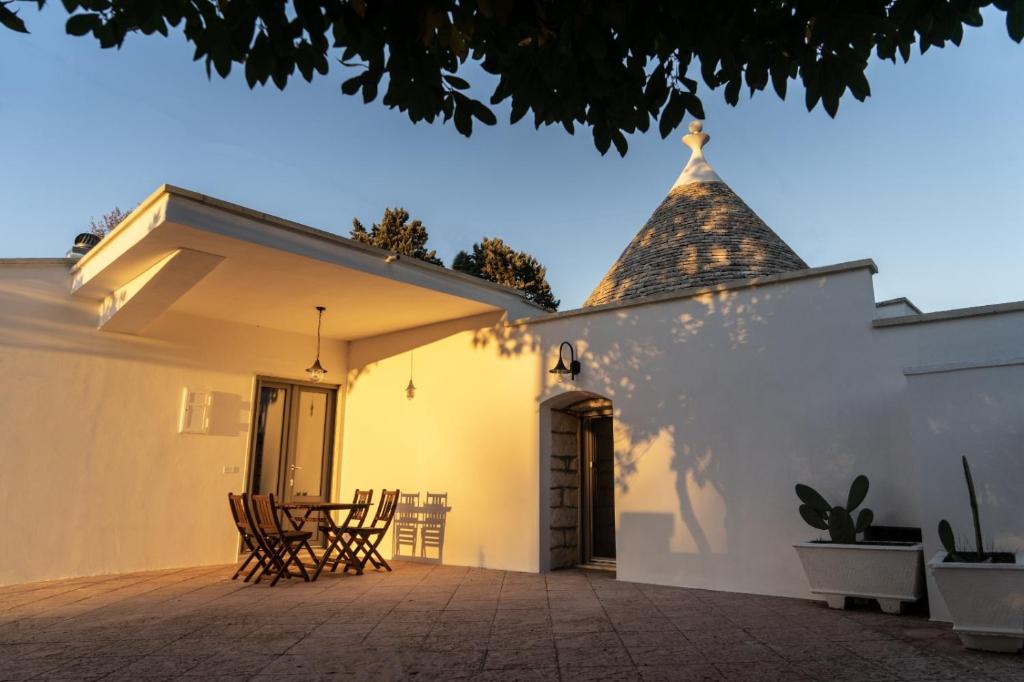 um pátio com cadeiras e um edifício com uma torre em Trullo Assiolo in Valle d'Itria em Martina Franca