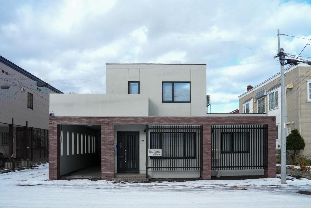 a red brick building with a garage at Canal Villa Otaru in Otaru