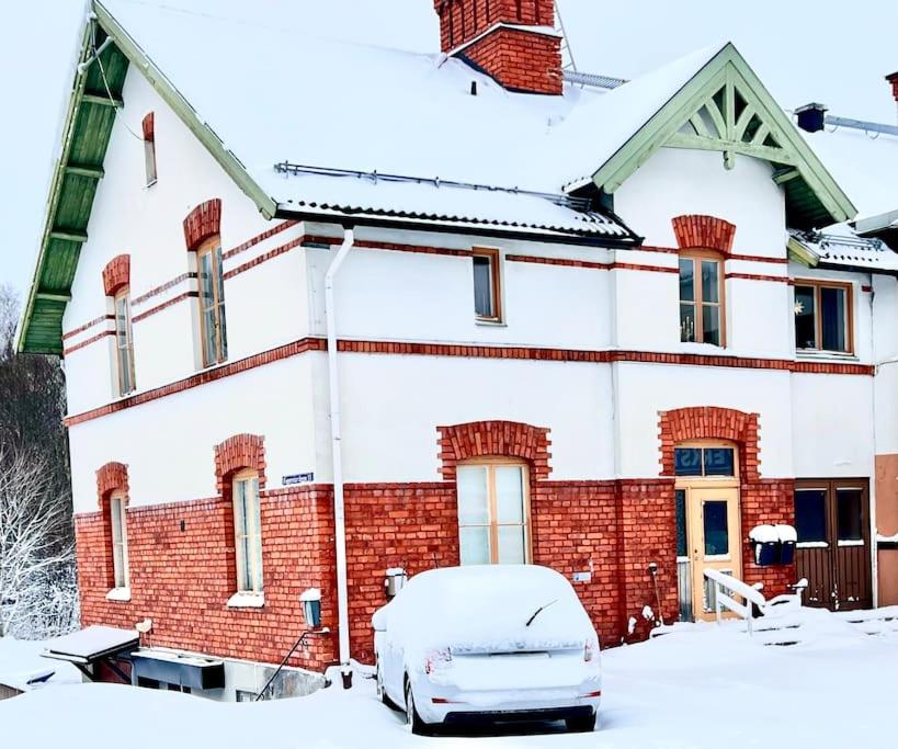 een besneeuwd huis met een auto voor de deur bij Centralt Skinnskatteberg 2 sovrum in Skinnskatteberg