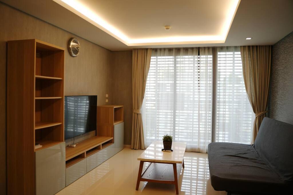 2 beds bangkok center max 6 في Klong Toi: غرفة معيشة مع أريكة وتلفزيون