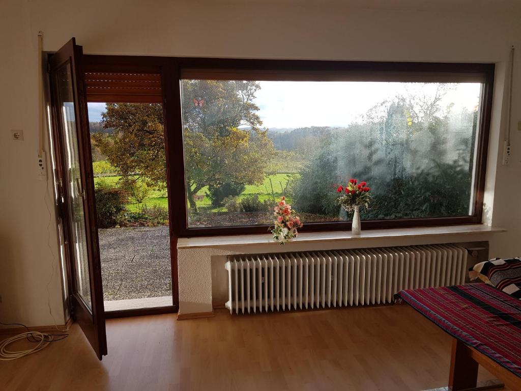 a living room with a large window and a radiator at Fewo Panoramablick in Winterscheiderbröl