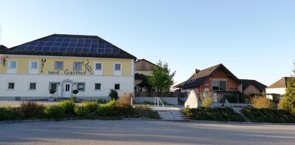 ein großes weißes Gebäude mit Sonnenkollektoren auf dem Dach in der Unterkunft Frühstückspension Wahl in Ruprechtshofen