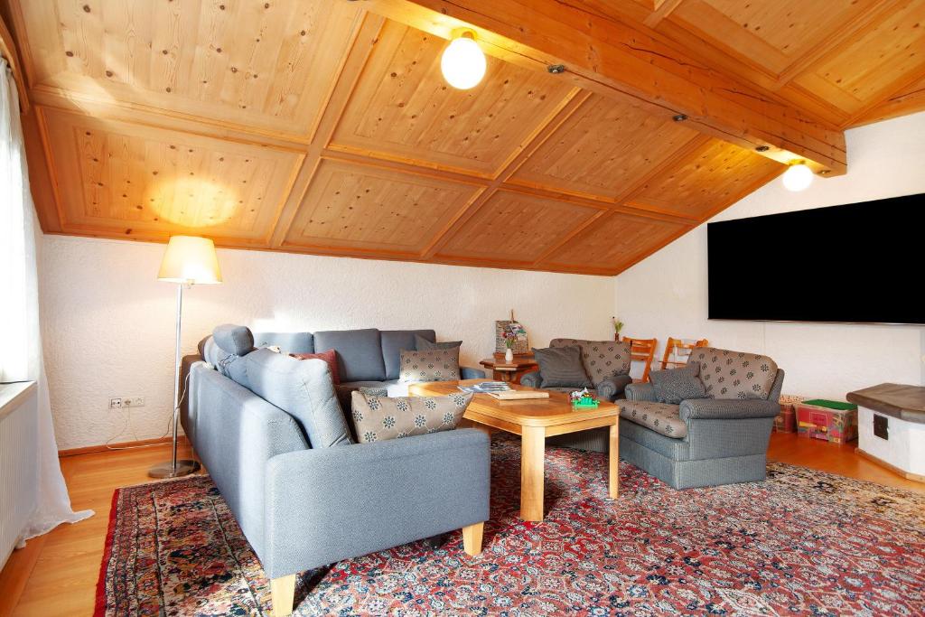 a living room with two couches and a flat screen tv at Ferienwohnung Caprano in Sonthofen