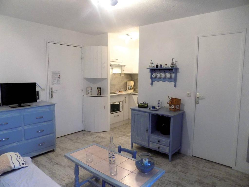 un salon avec une armoire bleue et une cuisine dans l'établissement Saint Georges de Didonne - AGREABLE APPARTEMENT - PROCHE PLAGE - Evasion Marine, à Saint-Georges-de-Didonne