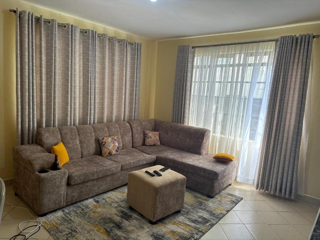 salon z kanapą i dużym oknem w obiekcie Chic Haven - Fully furnished 1 BR Gem w mieście Kiambu