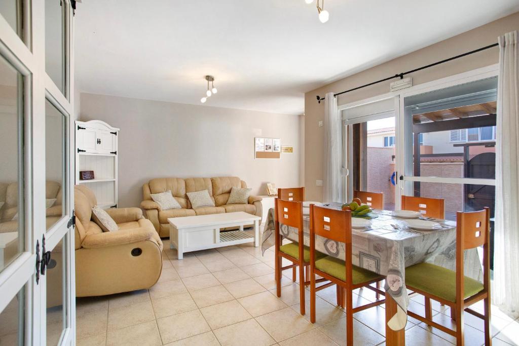 a dining room and living room with a table and chairs at Casa Velázquez in Puerto del Rosario