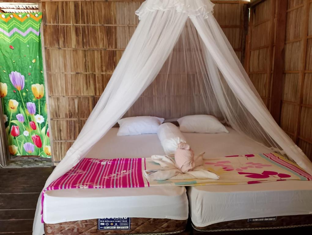 um quarto com uma cama e uma rede mosquiteira em Raja Ampat Diva homestay em Waisai