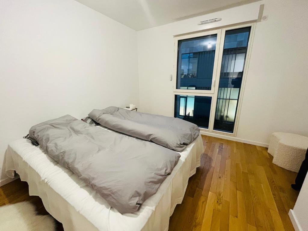 een witte slaapkamer met een bed en een raam bij Dream Dwell Paris-Fantastic modern flat near RER A Paris in Saint-Maur-des-Fossés
