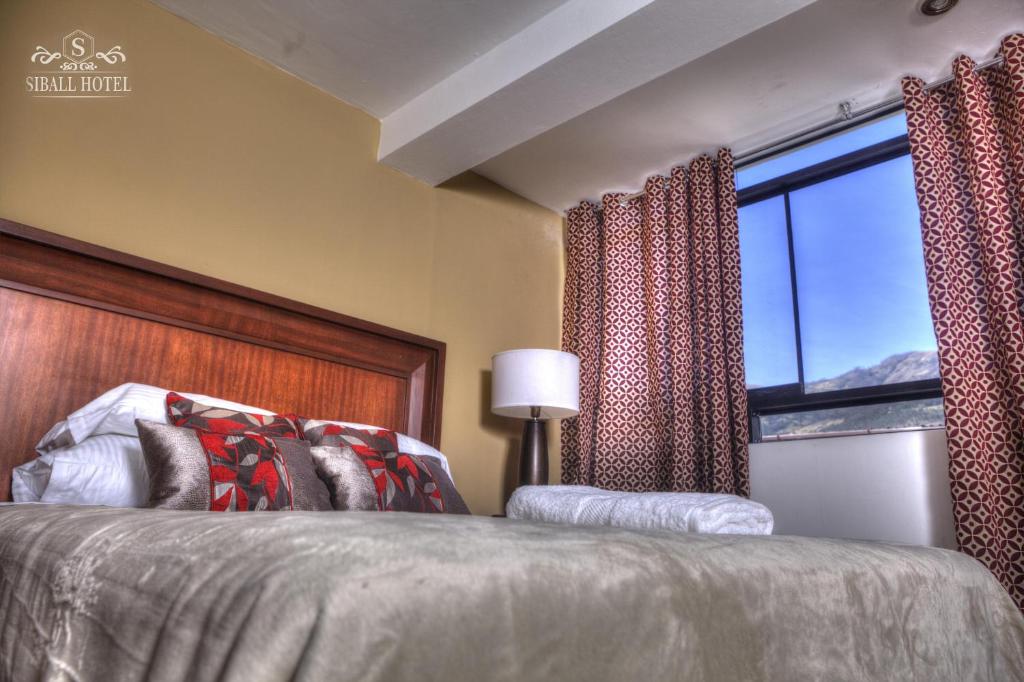a bedroom with a bed and a large window at Siball Hotel in Abancay
