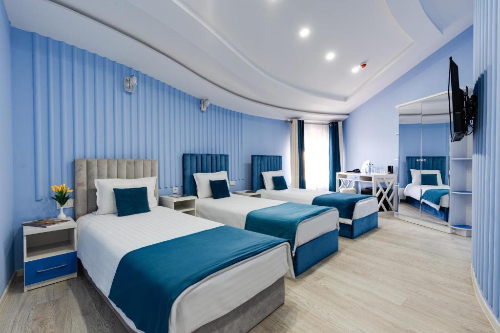 um quarto de hotel com duas camas e uma secretária em Shoxjahon Hotel - 600 Mbps Internet em Tashkent
