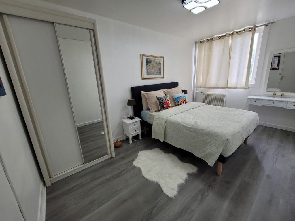 - une chambre avec un lit et une grande fenêtre dans l'établissement Charmante chambre chez l'habitant, à Ivry-sur-Seine