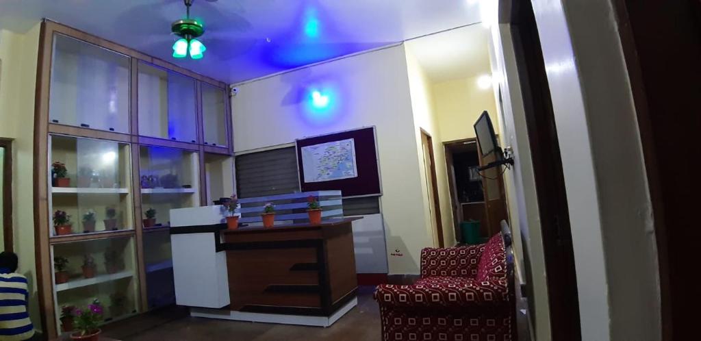 um quarto com uma secretária, uma cadeira e luzes azuis em Hotel Bhubaneswar Pride em Bhubaneshwar