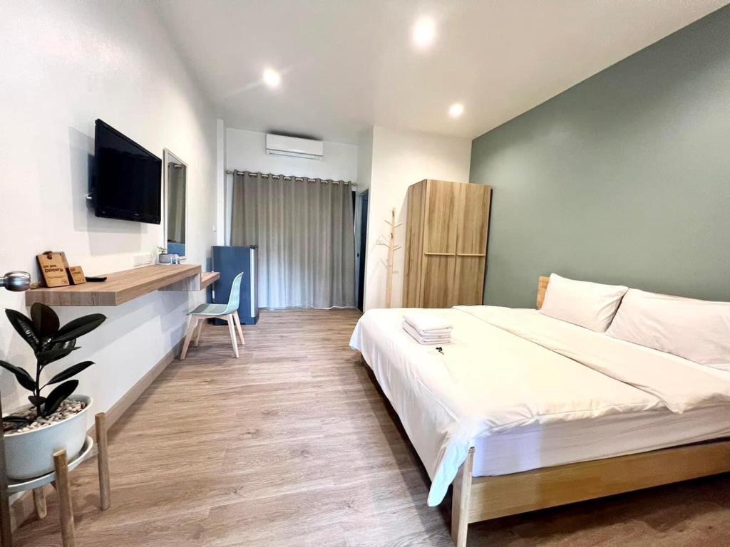 1 dormitorio con 1 cama blanca grande y escritorio en House 945, en Khon Kaen
