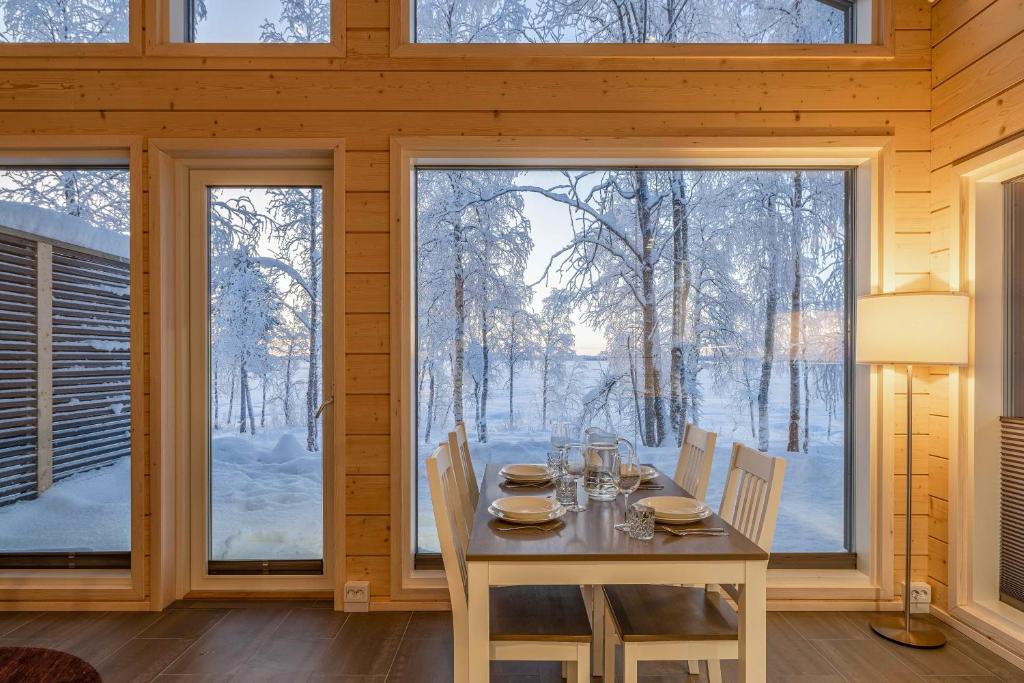 a dining room with a table and chairs and a large window at Miilu Resort in Ylläsjärvi