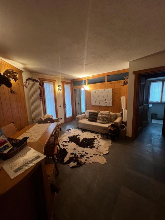 uma sala de estar com um sofá e uma mesa em Appartamento incantevole con box e ski room, Wi-Fi, Bormio em Bormio