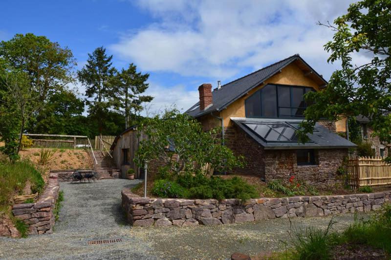 una casa con un camino de piedra que conduce a ella en La haie chapeau en Saint-Thurial