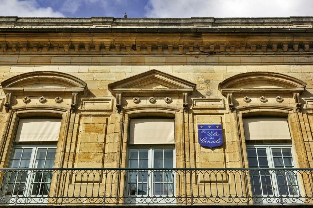 ein Gebäude mit Fenstern und einem blauen Schild darauf in der Unterkunft La Villa des Consuls - Gîte de tourisme de charme in Sarlat-la-Canéda