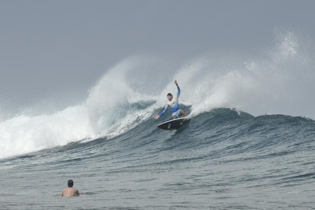 a man riding a wave on a surfboard in the ocean at EQ SURF RETREAT in Muli