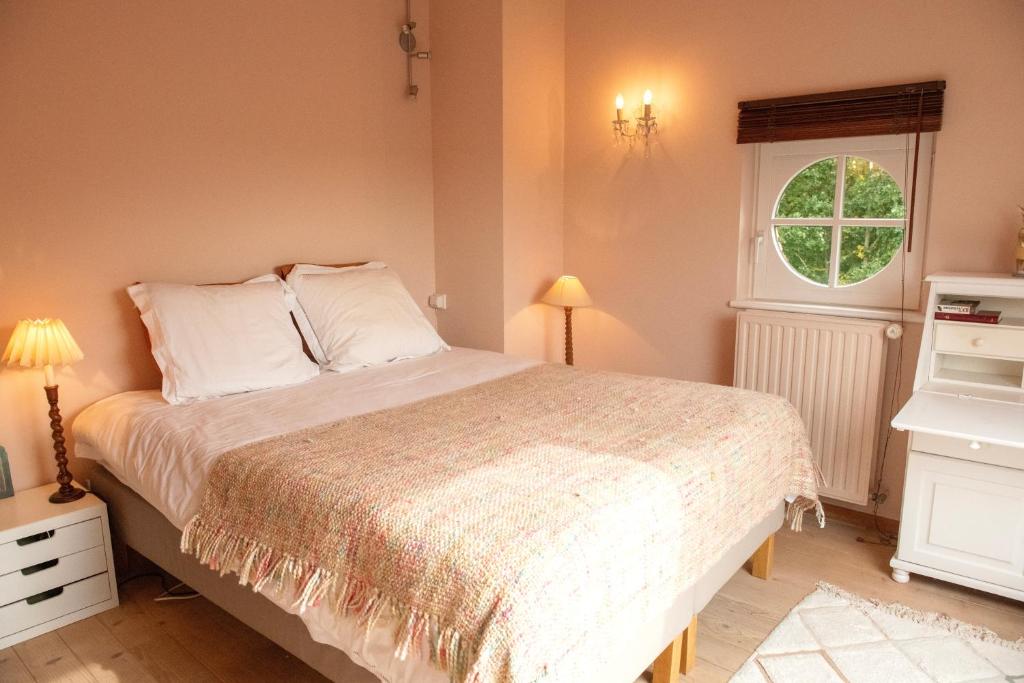 Un dormitorio con una cama grande y una ventana en Marie campagne en Mont-Saint-Guibert