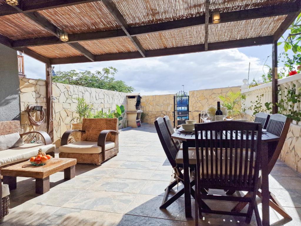 un patio al aire libre con mesa y sillas en MEDANO4YOU Montaña Roja Beach House, en El Médano