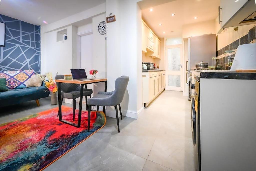 a kitchen and living room with a table and chairs at Jazzy 2BR Enfield Crib - Parking, Wi-Fi & Private Garden in Ponders End