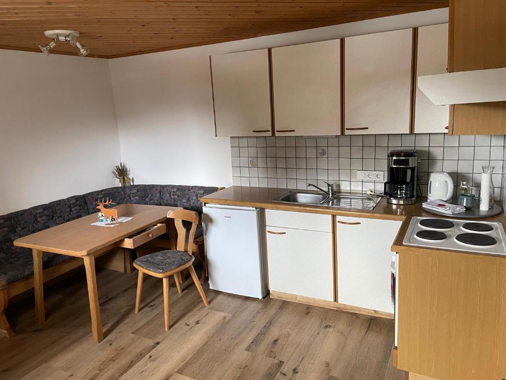 uma cozinha com uma mesa de madeira e uma mesa e uma mesa; em Ferienwohnung in ruhiger Lage in Bischofshofen em Bischofshofen