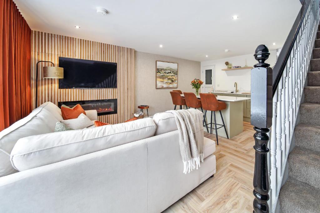 a living room with a white couch and a kitchen at The Burrow in Sion Mills