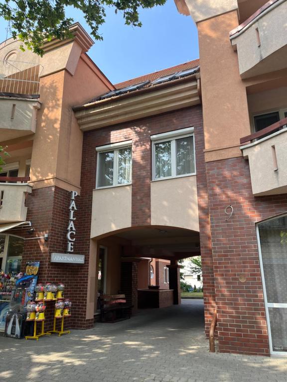 a brick building with an archway in front of it at Grace Apartman in Hajdúszoboszló