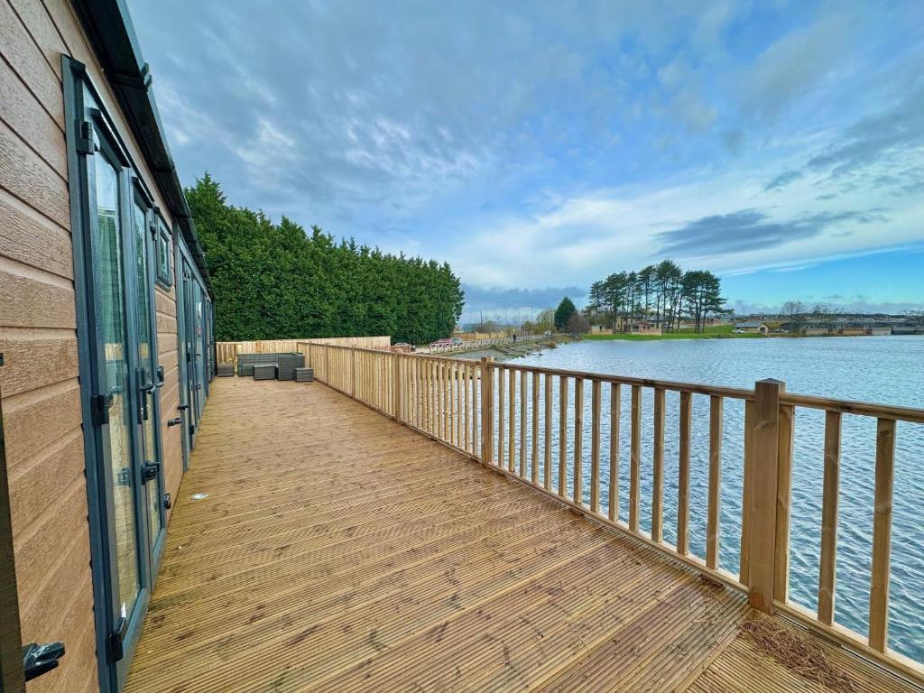 una pasarela de madera junto a un cuerpo de agua en Luxury Langham Lodge, en Clitheroe