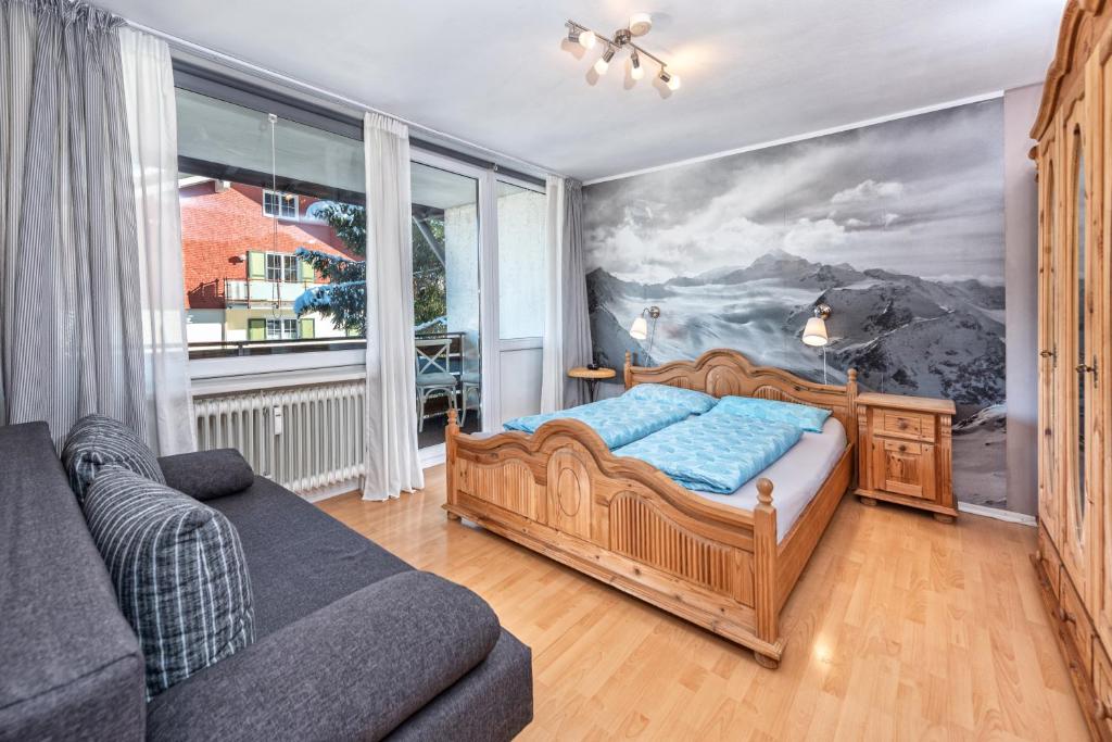 ein Schlafzimmer mit einem Bett und einem Sofa in der Unterkunft Alpenglöckchen Zentral in Oberstaufen
