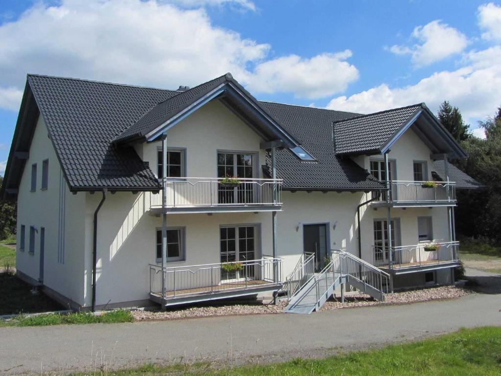 a white house with a black roof at Am Alten Forsthaus in Neuenbau