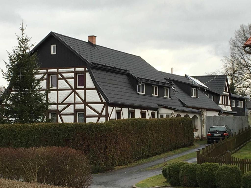 una casa en blanco y negro con techo negro en Ferienhof Homann, en Lindenberg