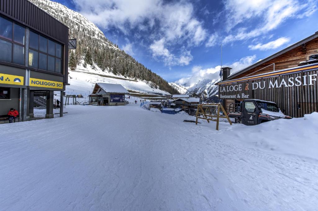 a snow covered parking lot in front of a building at Maison Checrouit in Courmayeur