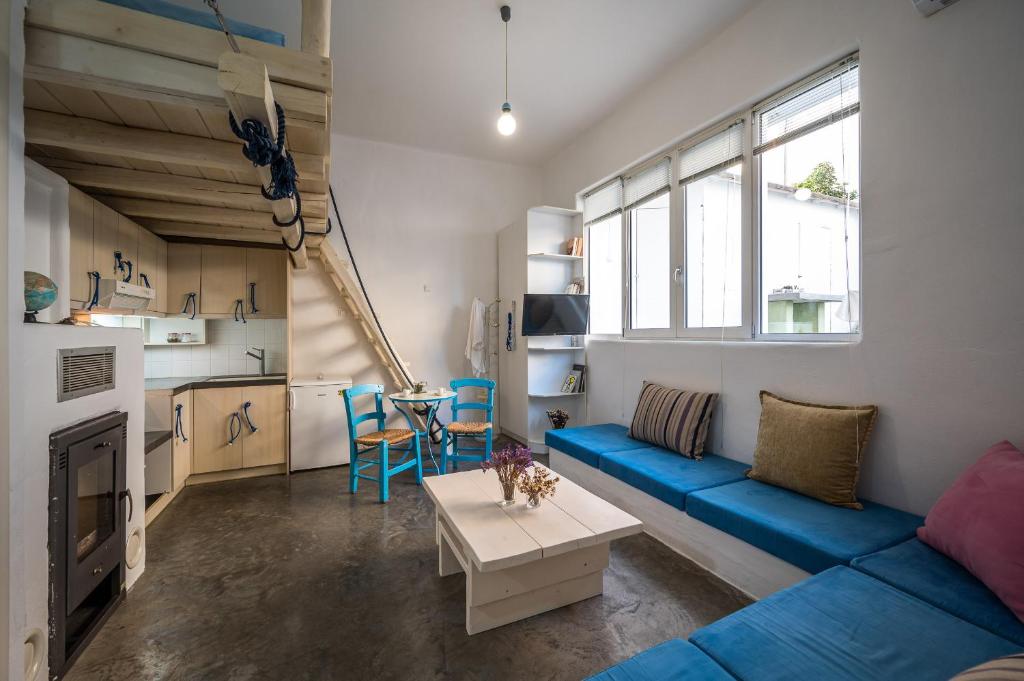 a living room with a blue couch and a table at Γκαρσονιέρα #2 υπνοδωμάτιο σε οντά in Heraklio Town