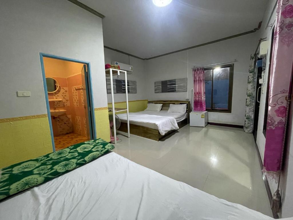 - une chambre avec 2 lits et un miroir dans l'établissement บุญพน รีสอร์ต Maldives resort&restaurant, à Wichian Buri