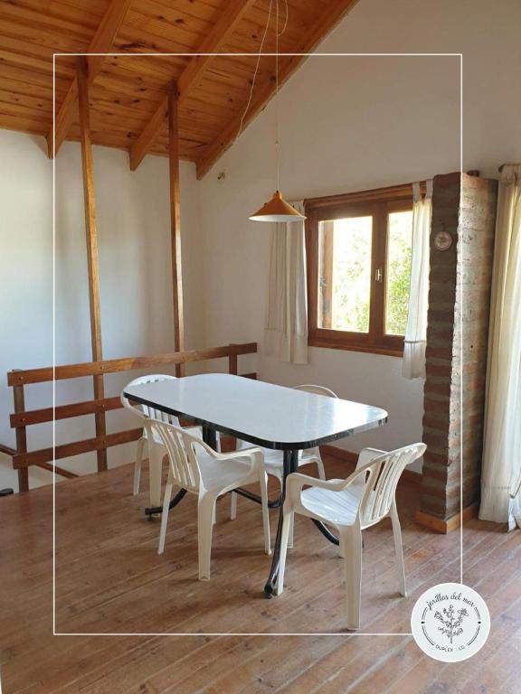 a dining table and chairs in a room with a table at Jarillas del Mar in Las Grutas