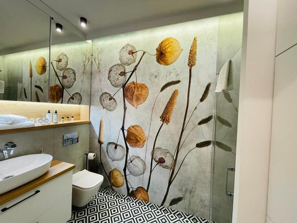 a bathroom with a shower with a flower mural at Drewnowska 77 Prime Apartment in Łódź