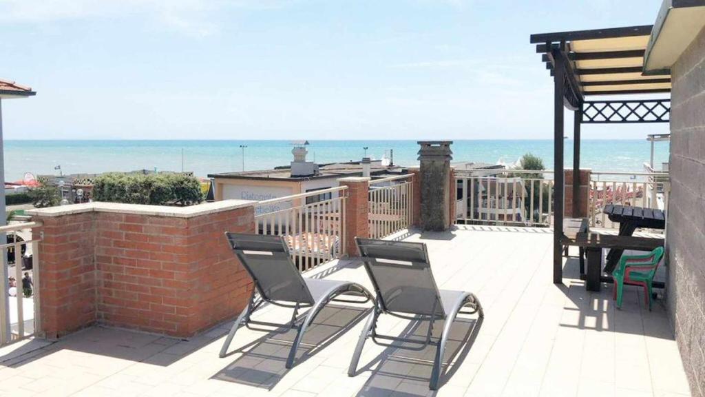 a patio with chairs and a table on a balcony at Villino Mirella a Marina di Cecina in Marina di Cecina