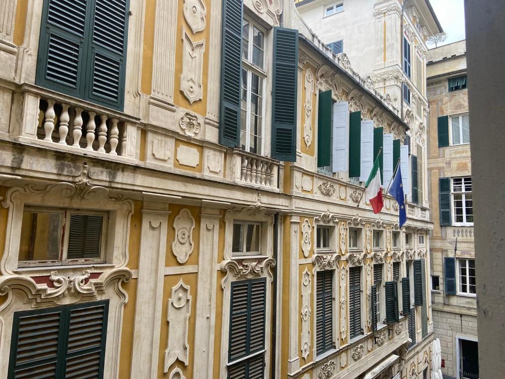um edifício com persianas verdes e bandeiras em Dimora Beatrice in Palazzo Pellicceria, palestra, vicino acquario em Gênova