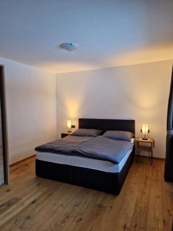 - une chambre avec un lit et deux lampes sur deux tables dans l'établissement Appartement Aigner, à Grossarl