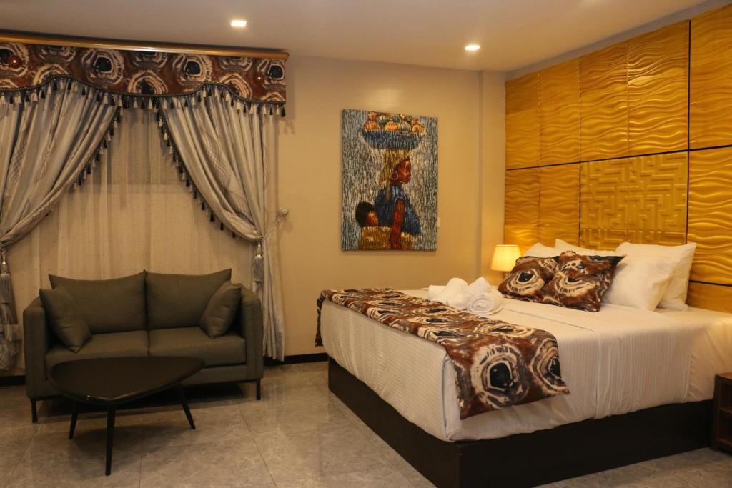 um quarto de hotel com uma cama e uma cadeira em Saire Hotels Ibadan em Ibadan