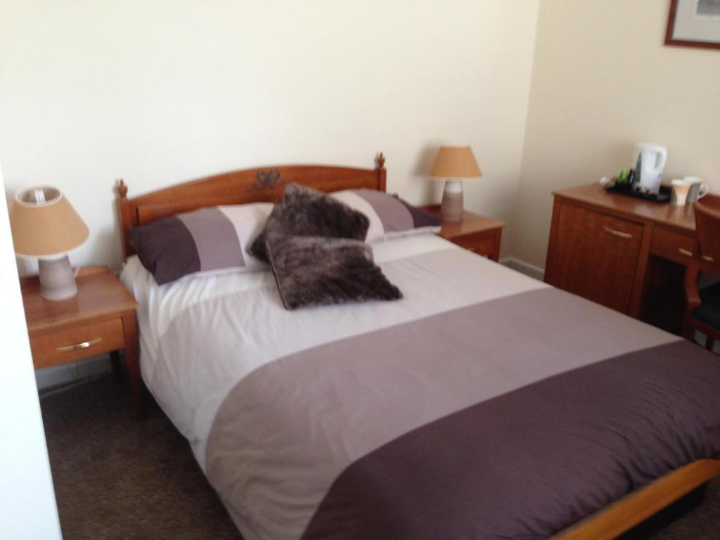 a bedroom with a large bed with pillows on it at Victoria hotel in Holywell