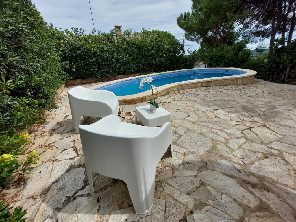 un lavabo y 2 sillas junto a una piscina en Chalet con piscina y barbacoa, Valencia en Torrent