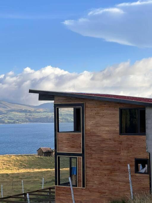a small wooden house with a view of the water at Villa San Jerónimo in Tota