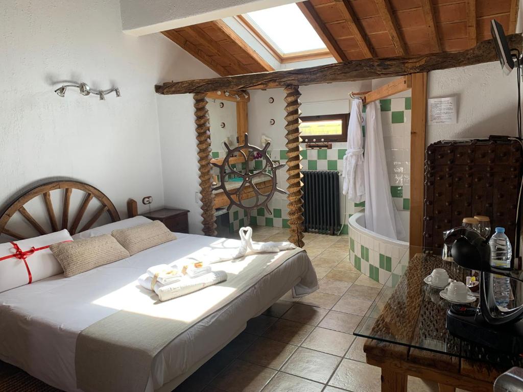 a bedroom with a bed and a tub in it at Habitaciones Rurales La Vertedera I in Villar de Ciervo