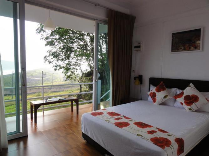 1 dormitorio con 1 cama y balcón con vistas. en Chomdao Baan Manisa, en Kiriwong