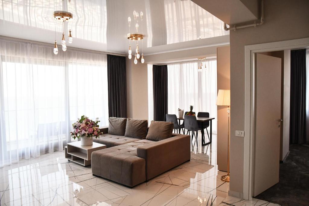 ein Wohnzimmer mit einem Sofa und einem Tisch in der Unterkunft Hotel Building Stefan Resort I in Mamaia Nord – Năvodari